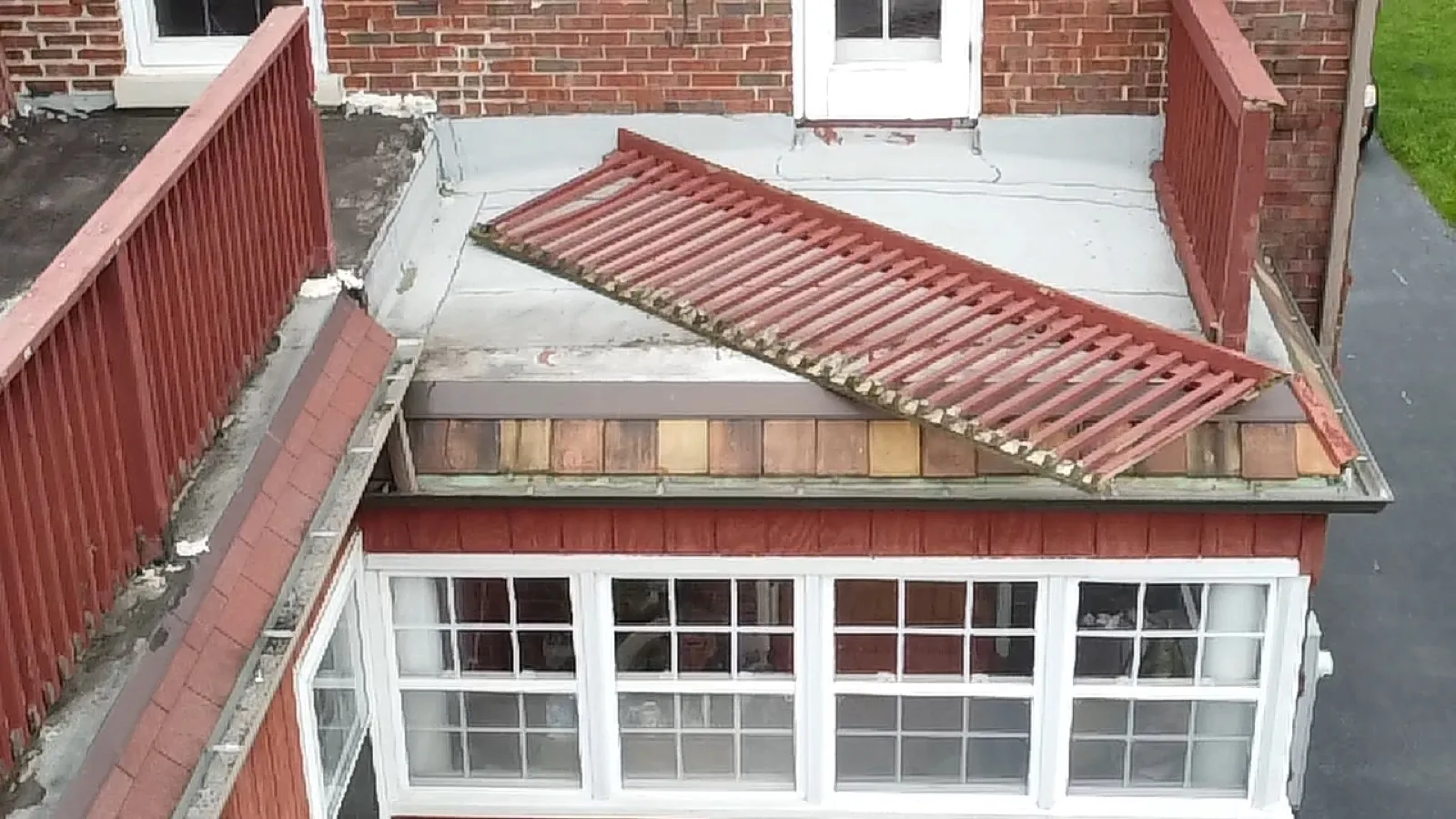 A metal roof section is being installed on a flat roof addition in Riverside, IL