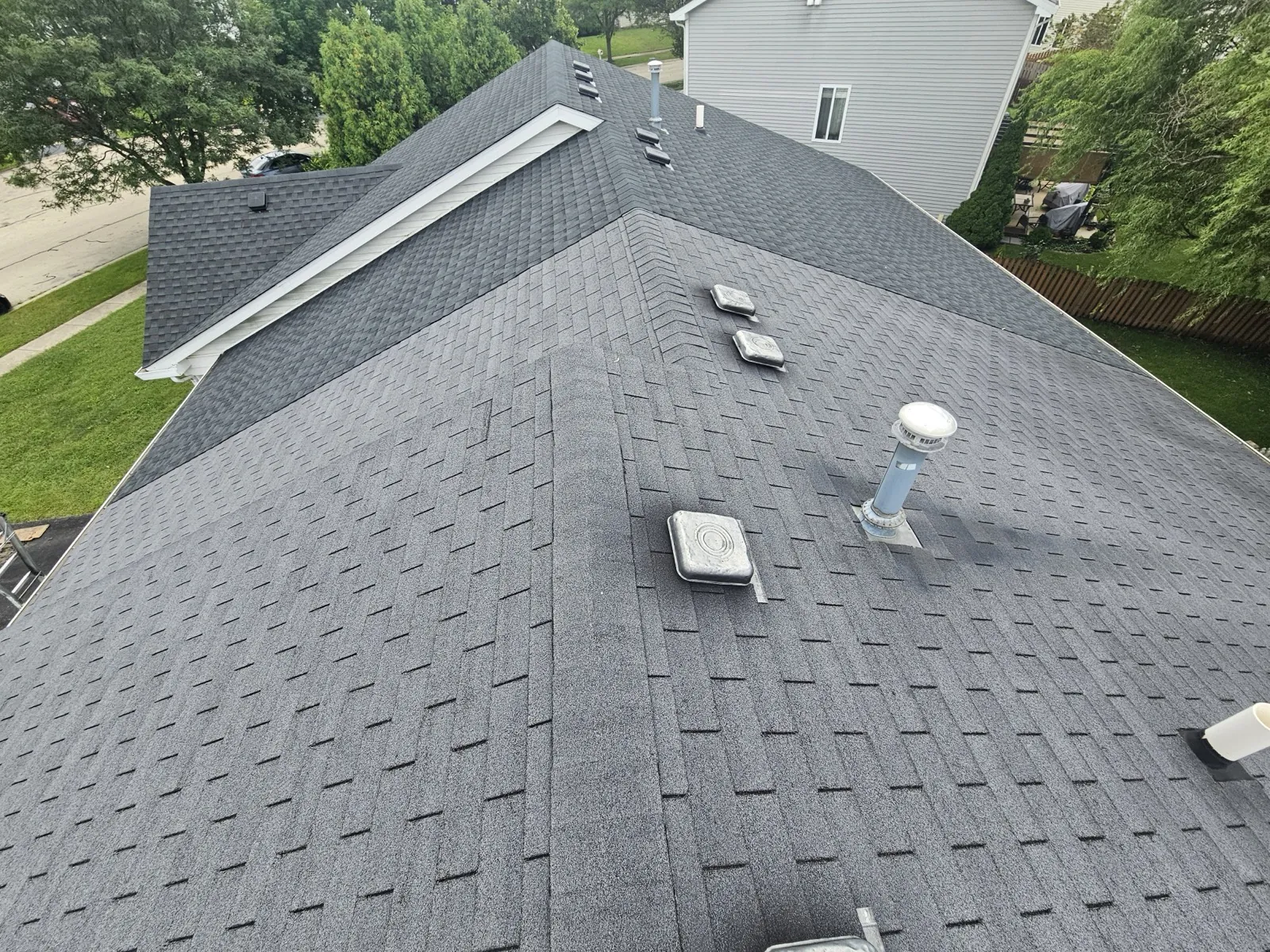 New charcoal gray architectural shingle roof on a multi-gabled home in Romeoville, IL