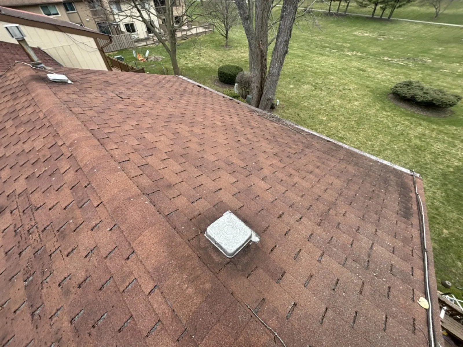 A brown asphalt architectural shingle roof with a roof vent in Roselle, IL