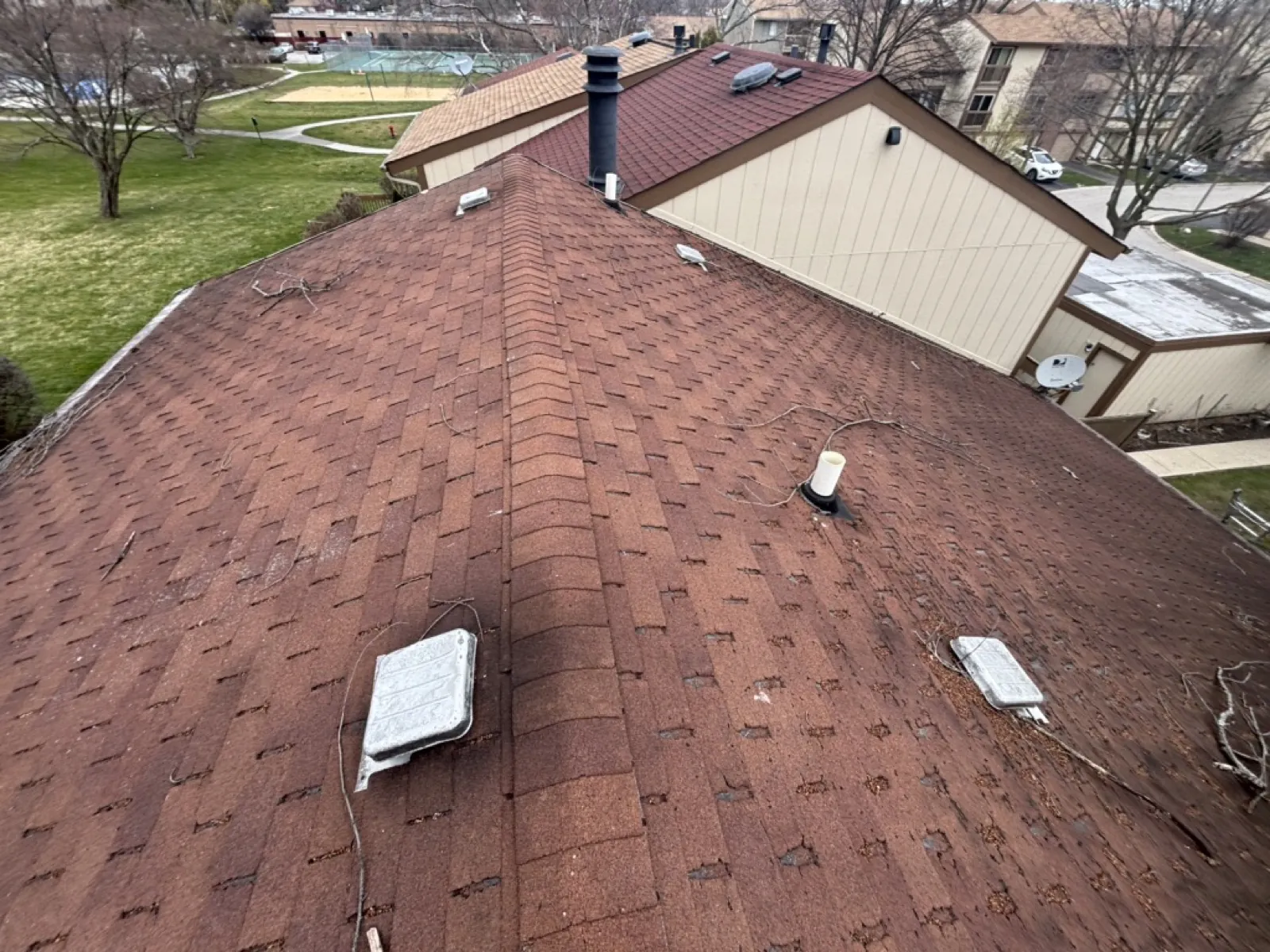 A brown asphalt architectural shingle roof on a multi-level residential building in Roselle, IL