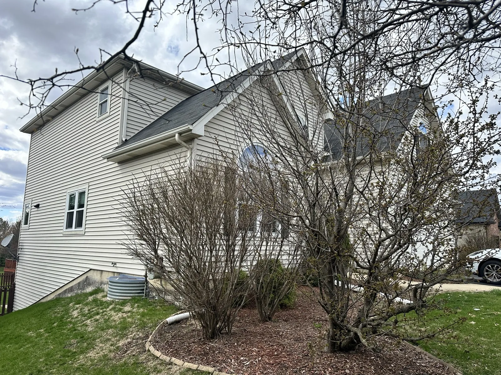 New charcoal architectural shingle roof on a two-story home with vinyl siding in South Elgin, IL