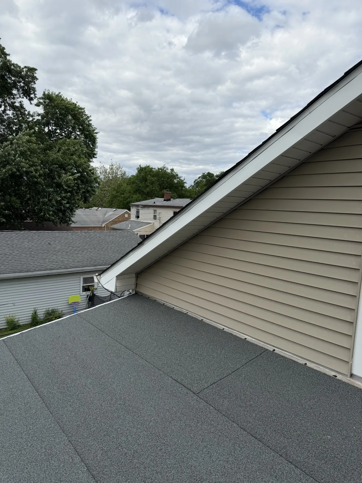 New charcoal architectural shingle roof on a home with tan siding in Villa Park, IL