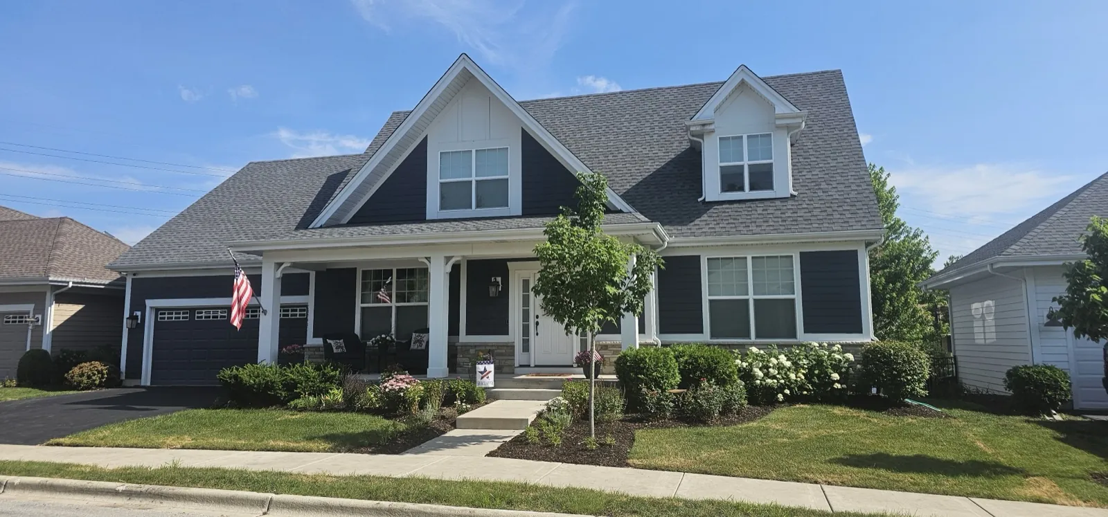 New charcoal gray architectural shingle roof on a two-story home with white trim in Warrenville, IL
