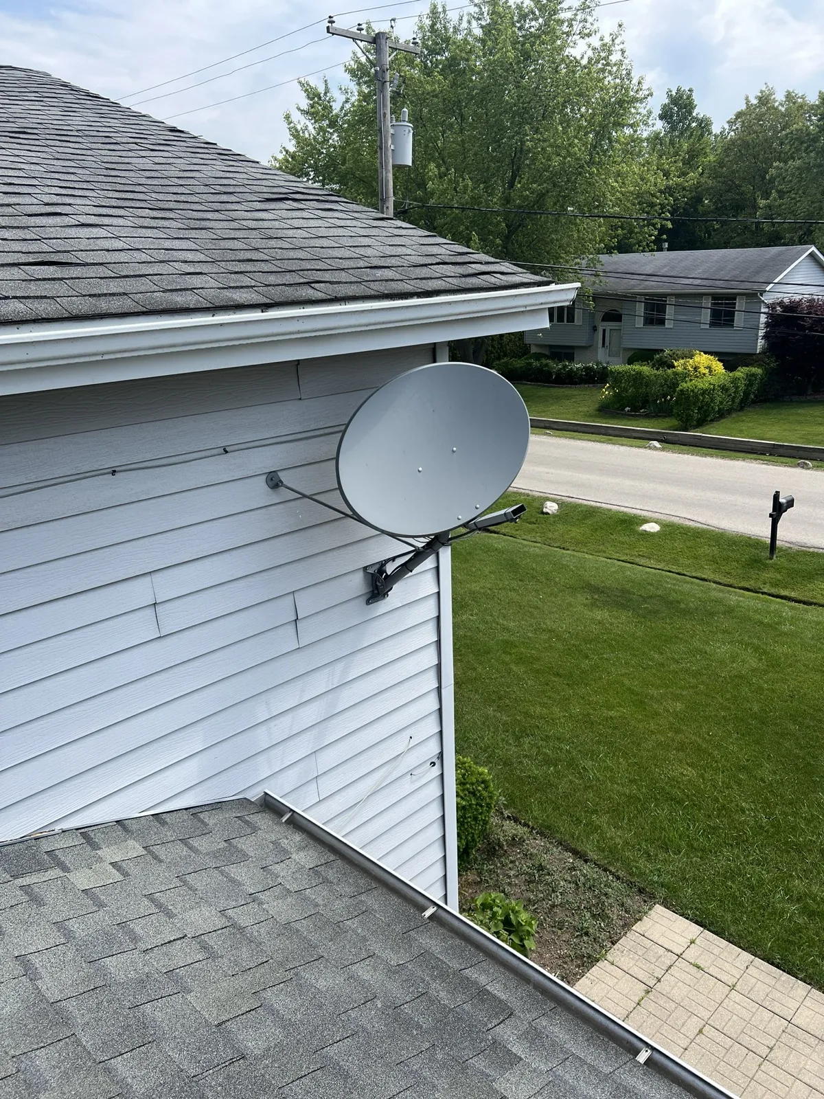 A gray asphalt architectural shingle roof on a house with white siding in Waukegan, IL