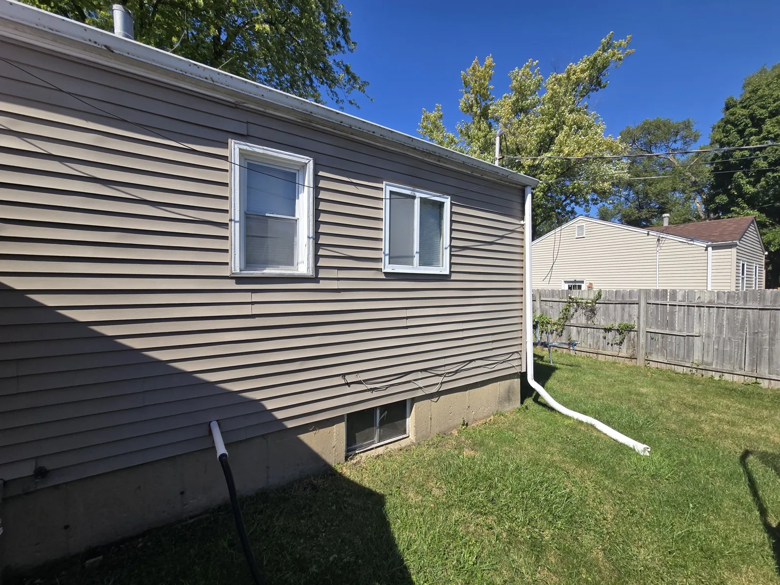 Tan vinyl siding on a residential home with white trim in Waukegan, IL