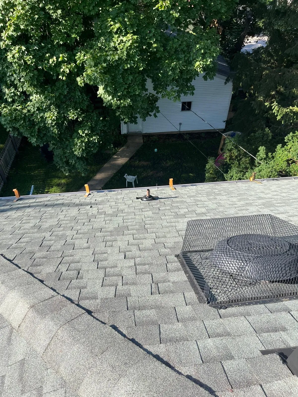 New gray architectural shingle roof with a protective screen over a roof vent in West Chicago, IL