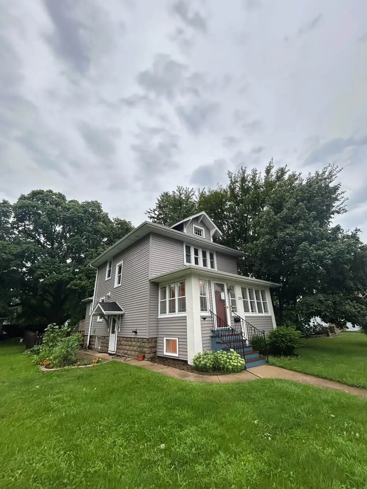 New gray asphalt architectural shingle roof on a two-story home with gray siding in West Chicago, IL