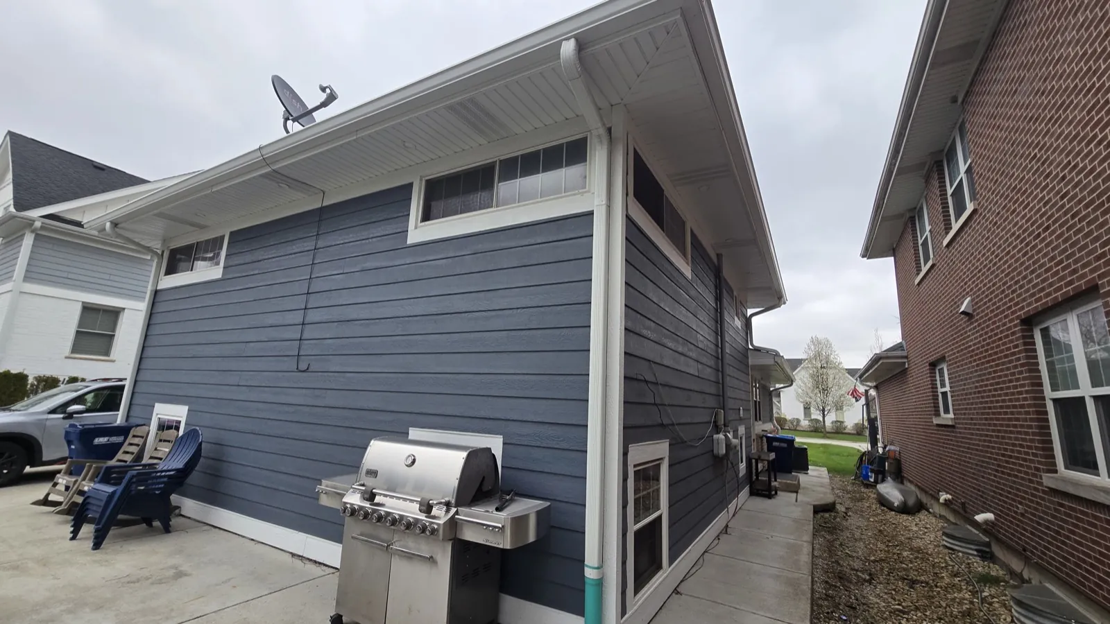 Blue vinyl siding on a residential building with white trim in Western Springs, IL