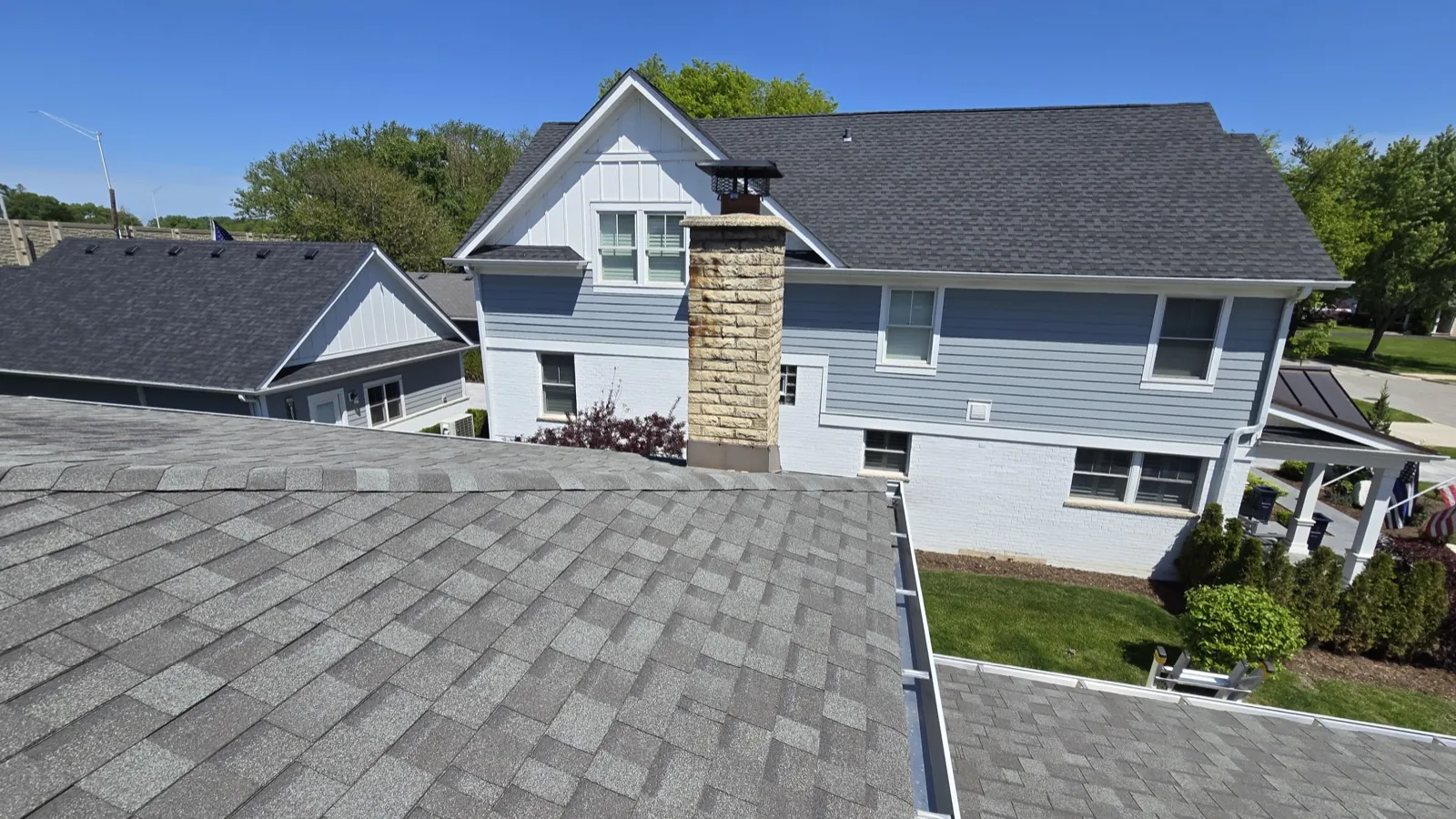 New charcoal gray architectural shingle roof on a multi-story home with blue siding in Western Springs, IL