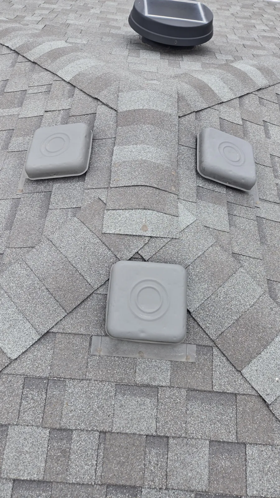 Close-up of a gray architectural shingle roof featuring decorative patterns and ventilation caps in Western Springs, IL