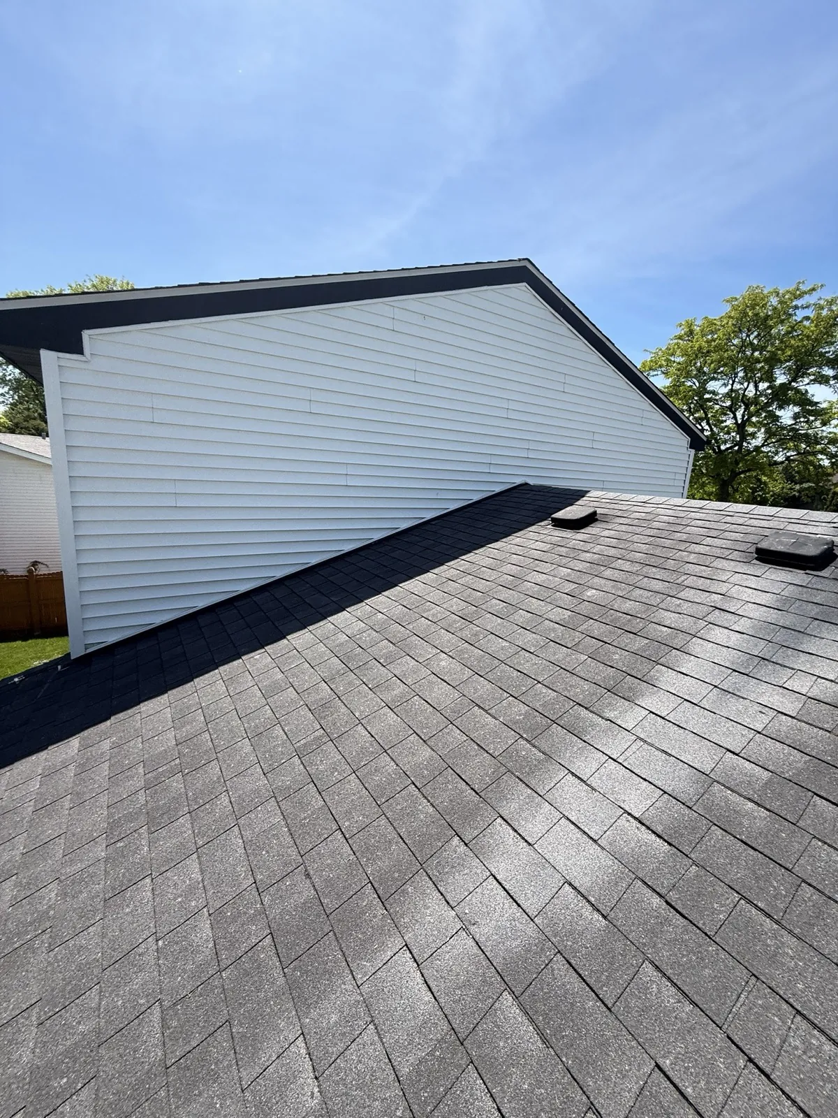 New charcoal gray architectural shingle roof on a home with white siding in Westmont, IL