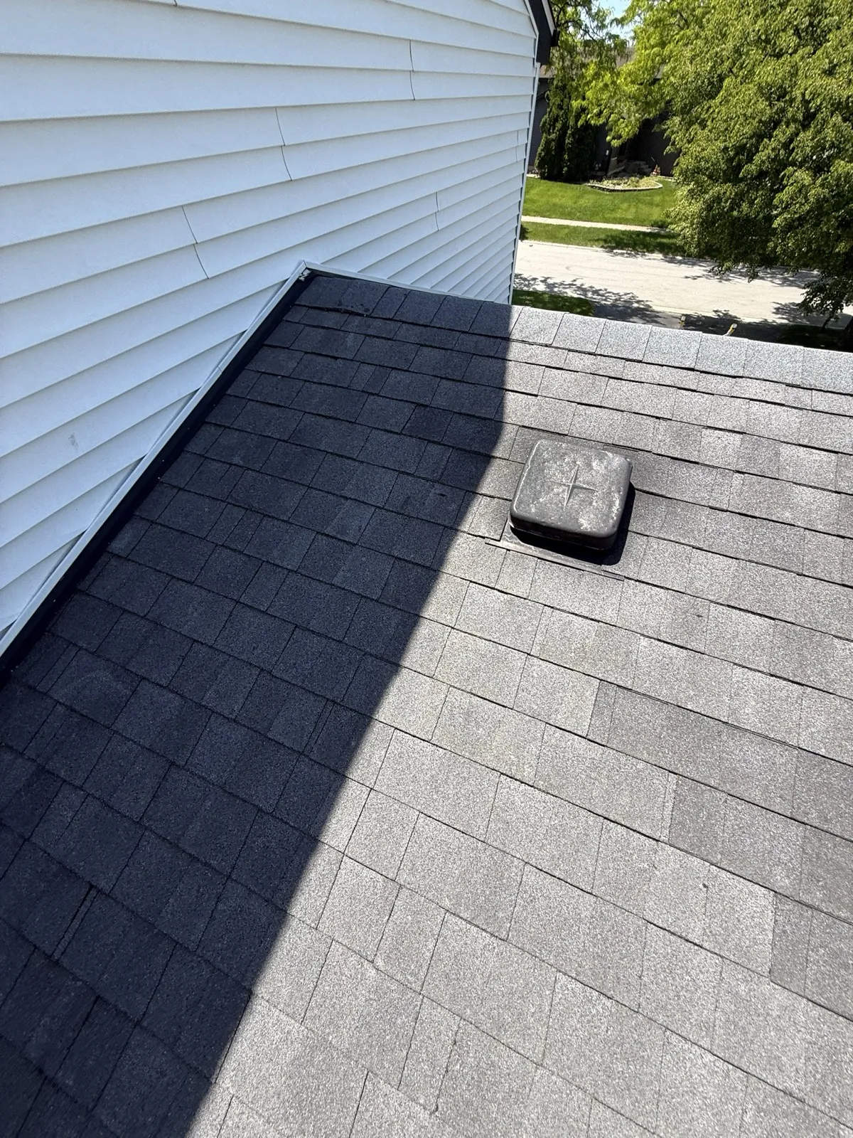 New charcoal gray architectural shingle roof with white vinyl siding in Westmont, IL