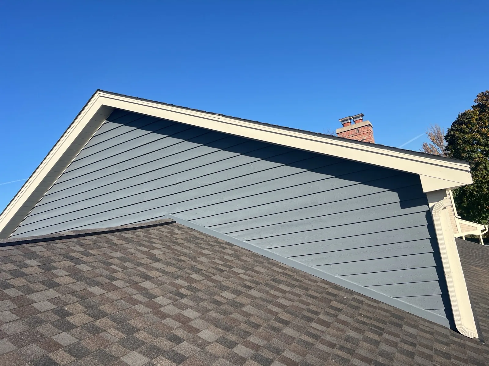 New charcoal architectural shingle roof on a home with blue siding in Winfield, IL