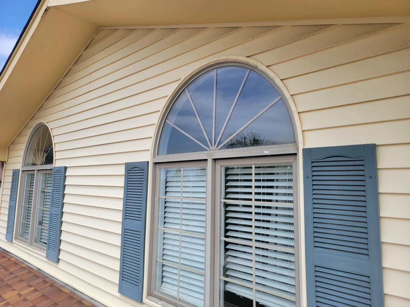 Beige vinyl siding on a home with arched windows and blue shutters in Woodridge, IL